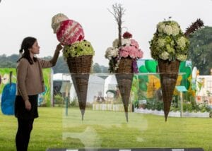 An Rhs Member Of Staff Inspects The Floral Displays In The Flower School At The Rhs Flower Show Tatton Park 2019.