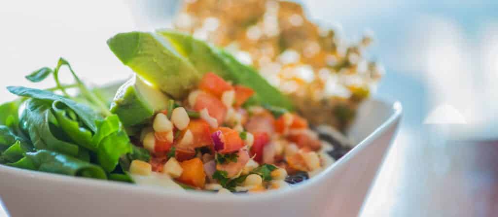 healthy mexican salad with seed cracker in modern white bowl